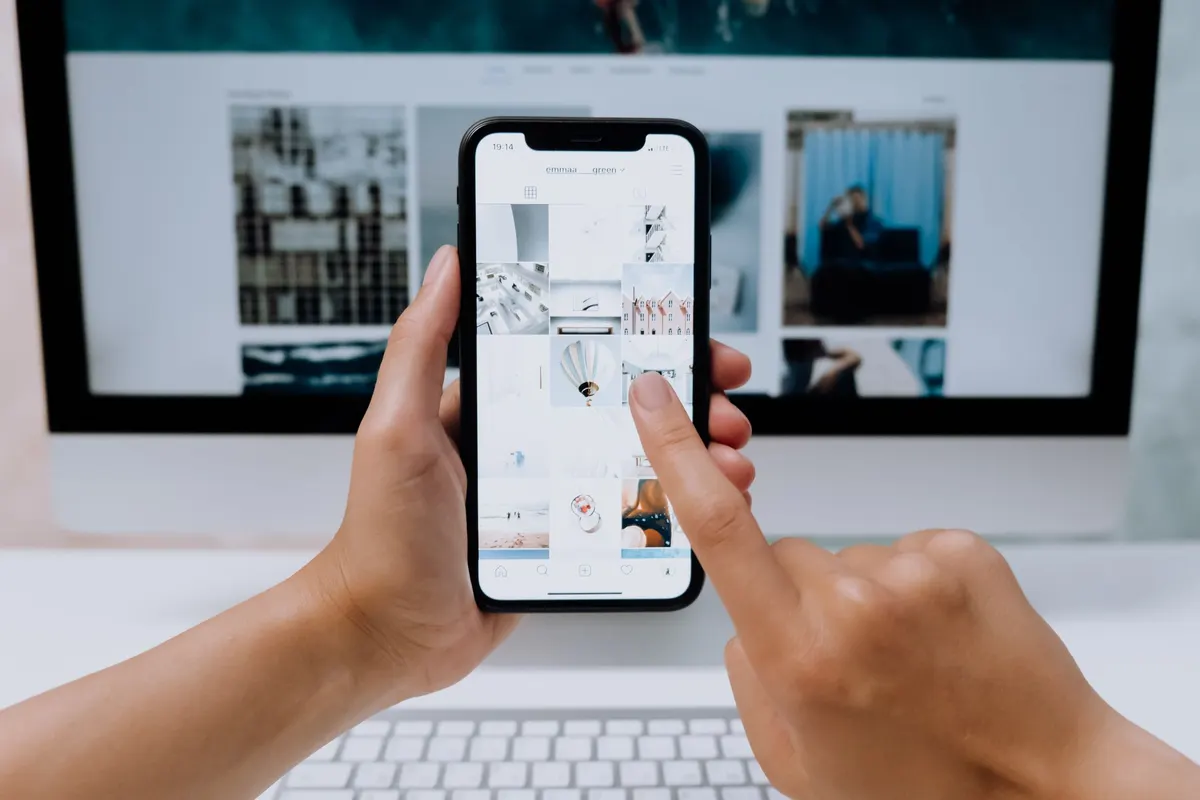 Hands holding a phone showing a website