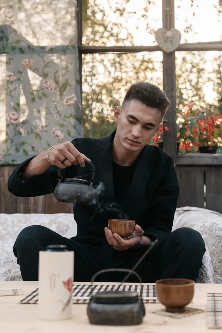 A man pouring tea at a small table