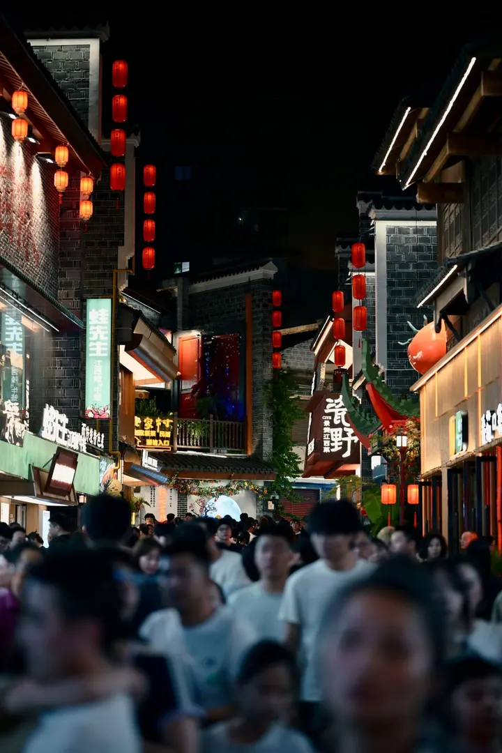 A busy street lit by lanterns at night