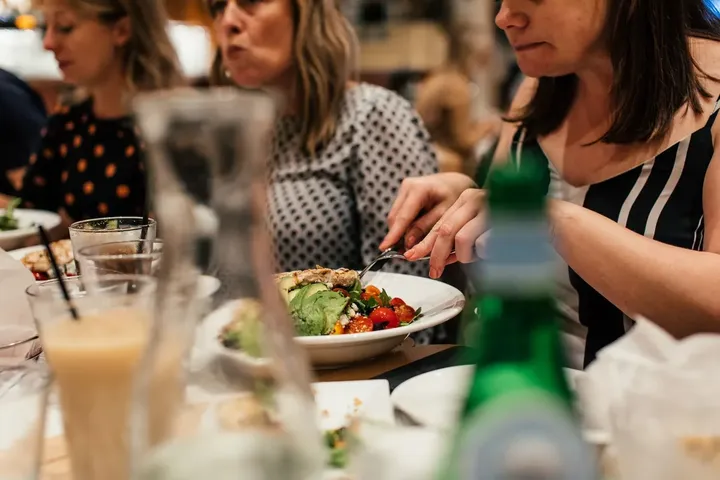Friends sharing dishes at a restaurant table