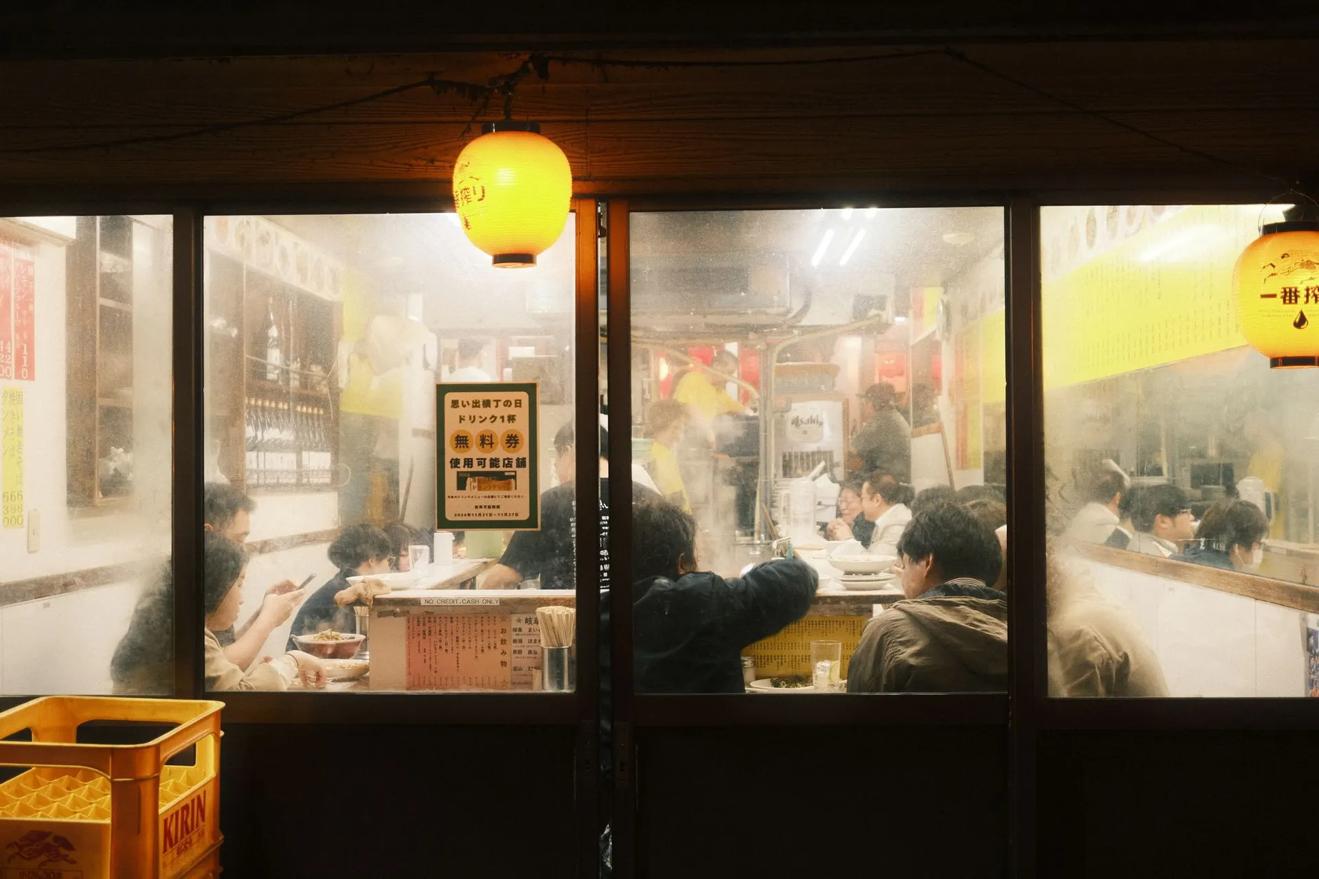 夜晚从街边看进去，一家热闹的居酒屋