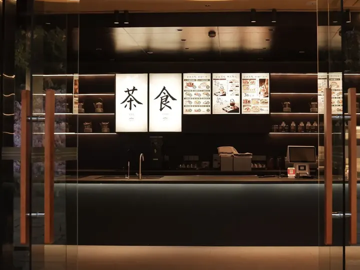 A tea shop storefront lit up at night