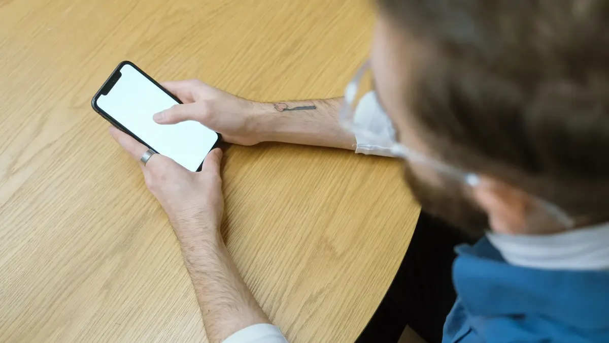 A man checks a restaurant on his phone at a table