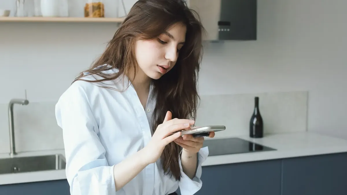 一位本地博主在厨房里用手机拍摄菜品