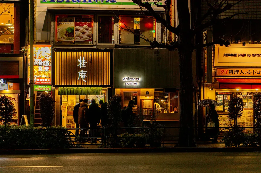 A street of lit restaurant fronts at night