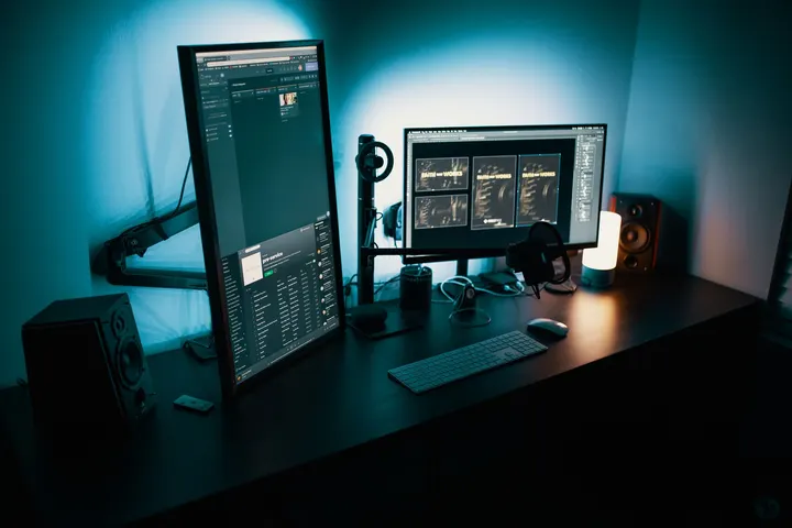 A desk with two monitors showing analytics dashboards