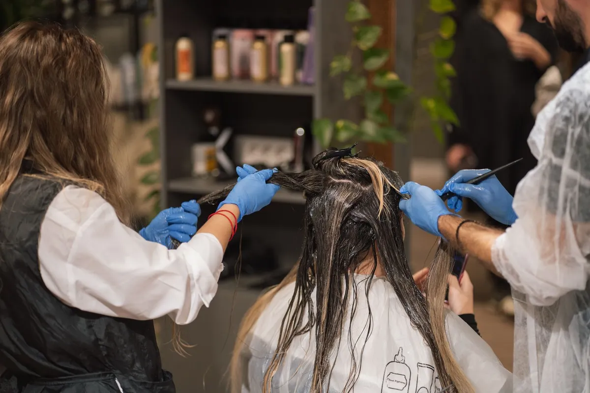 Stylist finishing a client’s hair color
