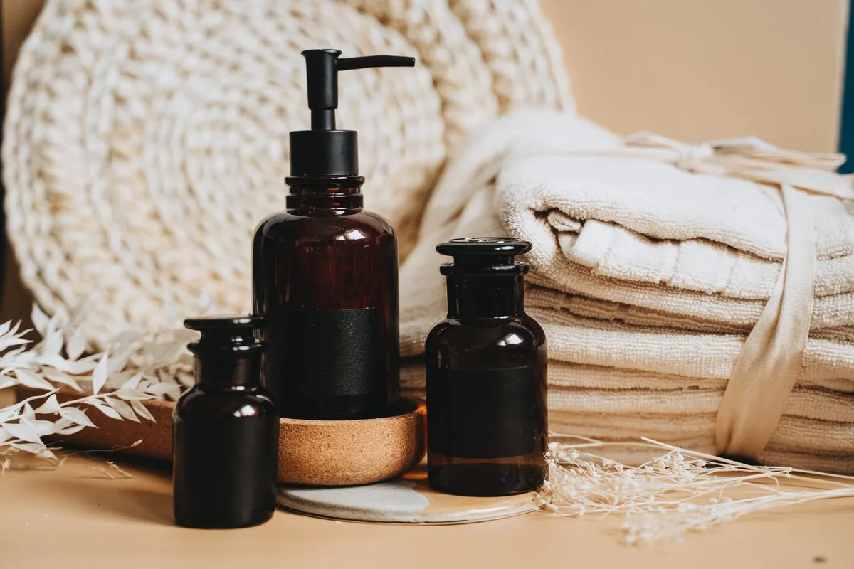 Massage oils and rolled towels on a shelf