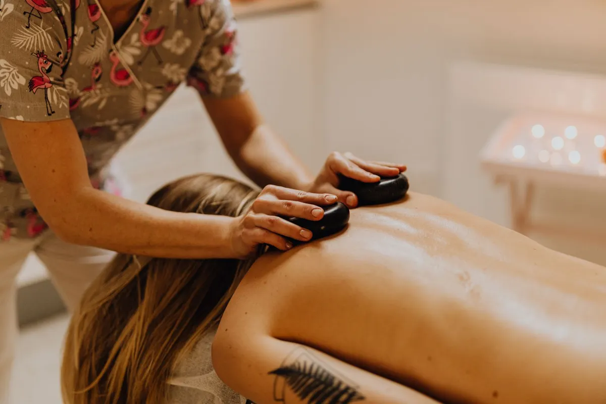 Therapist placing warm stones on a client’s back